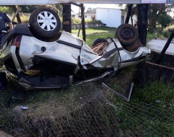 Motorista invade terreno, bate em placa e capota