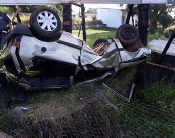 Motorista invade terreno, bate em placa e capota