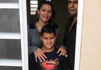 O casal Emerson e Tamires com o filho na janela da casa própria
